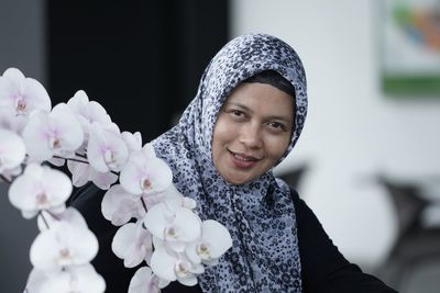 Portrait of woman wearing hijab by flowers