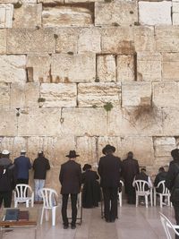 Rear view of people walking in front of historical building