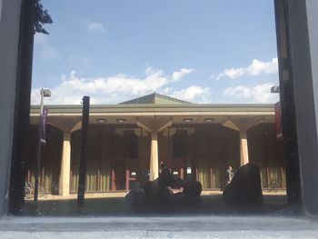 People sitting in building against sky