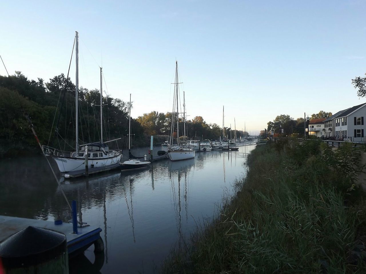 SAILBOATS MOORED AT HARBOR