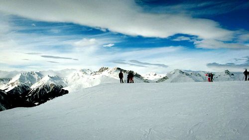 People on snowcapped mountain against sky