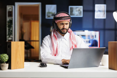 Young businesswoman using laptop at table