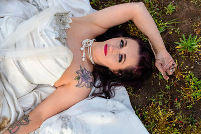 Portrait of smiling young woman lying on field