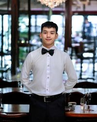 Portrait of young man standing in cafe