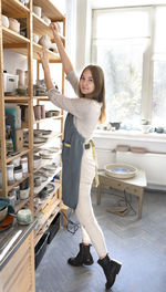 Female ceramist presents a new collection of ceramic tableware in the studio of clay and sculpture.
