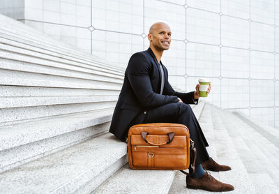 Side view of businessman using laptop while sitting on table