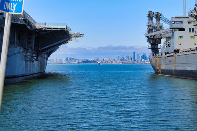 View of city by sea against blue sky