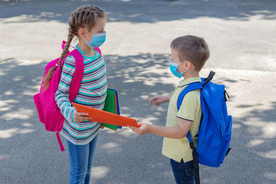 Back to school. brother and sister or boy and girl wearing protective medical masks 