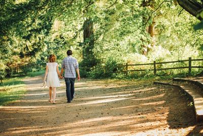 Rear view of woman walking on footpath