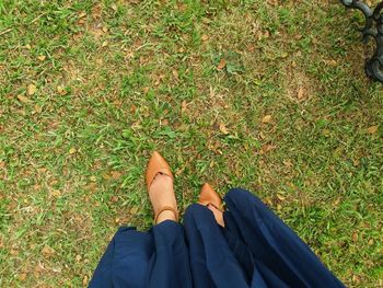 Low section of woman standing on field