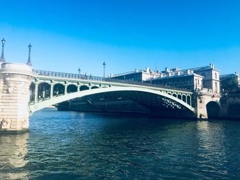 Bridge over river against blue sky