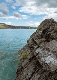 Rock formations by sea against sky