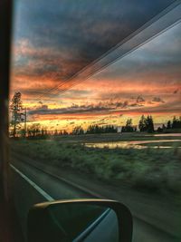 Scenic view of sunset seen through car window