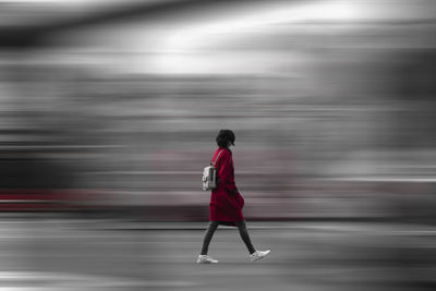 Rear view of woman walking on road