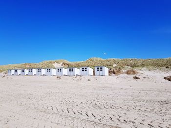 Built structure on beach against clear blue sky