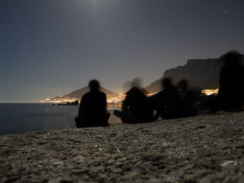 Silhouettes of people on night beach