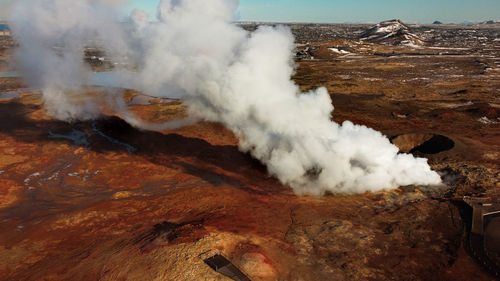 High angle view of smoke emitting from volcanic landscape