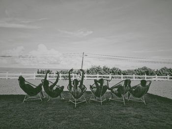 Chairs on beach against sky