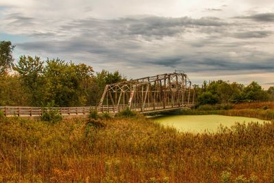 Bridge against trees on landscape against sky