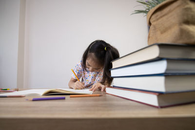 Side view of woman reading book at home