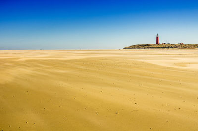 Scenic view of beach against clear blue sky