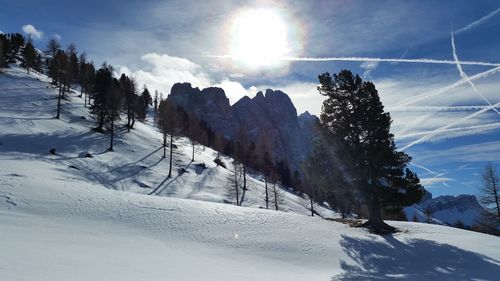 Sun shining over snow covered mountain