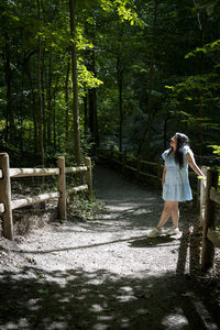 Rear view of woman standing in forest