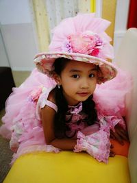 Portrait of cute girl in hat and dress at home