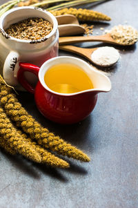 High angle view of oil in jar with reeds and wheat on table