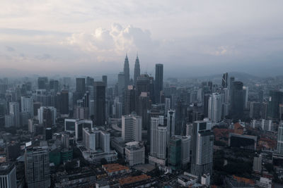 Aerial view of buildings in city against sky