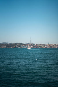 Sailboats in sea against clear blue sky