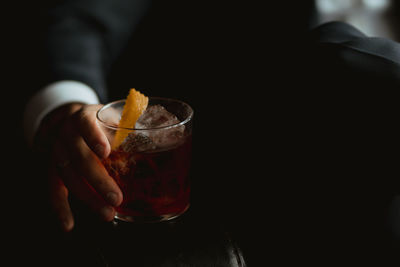 Midsection of person holding glass of whisky