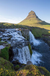 Scenic view of waterfall against sky