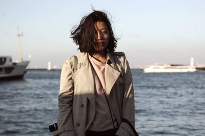 Portrait of beautiful woman standing against sky