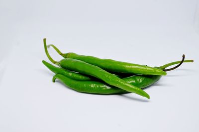 Close-up of green chili pepper against white background