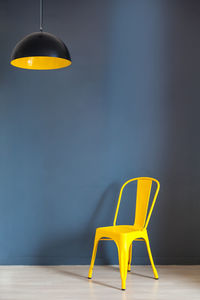 Empty chair on table against wall at home