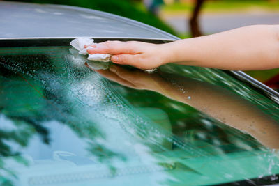 Cropped hand of person cleaning car