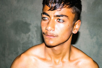 Close-up portrait of young man against wall