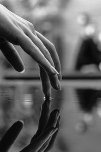 Cropped hand of woman touching water