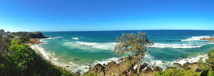 Panoramic view of sea against clear blue sky