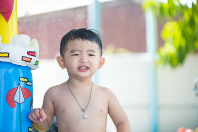 Portrait of shirtless baby boy standing outdoors