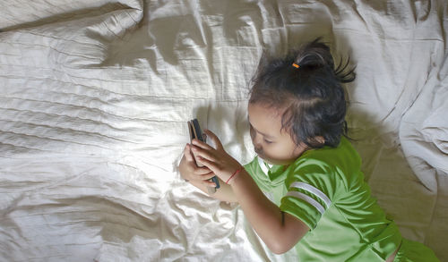 High angle view of cute girl on bed at home