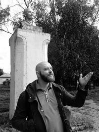 Man gesturing by sculpture at park