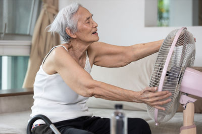 Midsection of man playing guitar at home