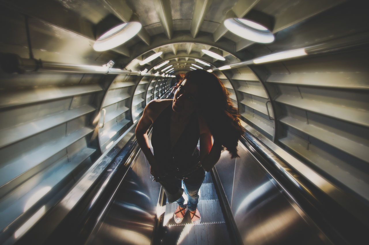 REAR VIEW OF A WOMAN WALKING ON SUBWAY