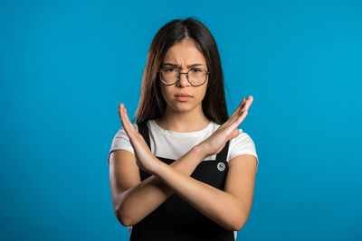 Portrait of a beautiful young woman against blue background