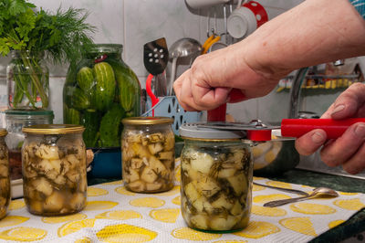 Midsection of man preparing food in jar on table