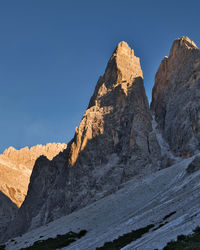 Rock formations on mountain against clear blue sky