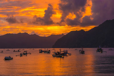 Tranquil scene floating boats on a bay at sunset, with mountains  near trenggalek, indonesia