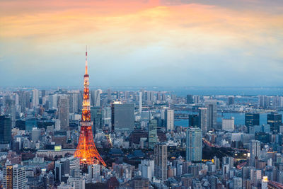 Aerial view of buildings in city against cloudy sky